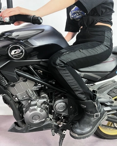 Detail of slim-fit motorcycle jeans with mesh panels and metallic side zipper accents