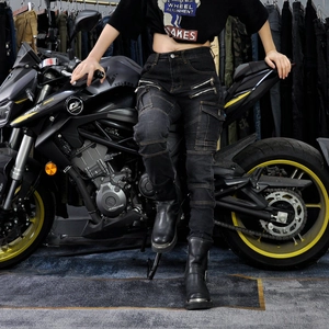 Women's black motorcycle jeans with knee armor and side zipper pockets beside a motorbike