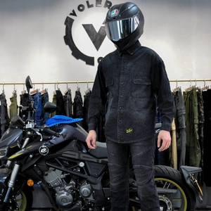 Detail eines schwarzen Motorrad-Fahrsets aus Denim-Hemd und Hose mit Dehnfalten am Knie