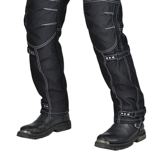 Detail view of motorcycle pants with white stitching and leather boots with metal buckles