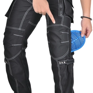 Detail of inserting a blue honeycomb knee protector into black motorcycle riding pants