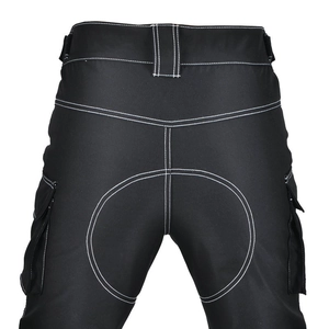 Detail of waterproof motorcycle pants with white contrast stitching and cargo pockets
