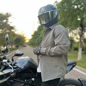 Close-up of a grey motorcycle riding shirt with chest pockets in an outdoor street setting
