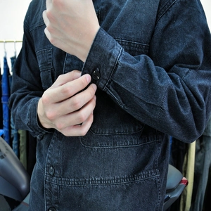 Detail der schwarzen Motorrad-Jeansjacke mit verstärkten Nähten und Knöpfen im Retro-Stil