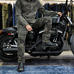 Men's camouflage motorcycle jeans with protective gear shown on a rider on a bike