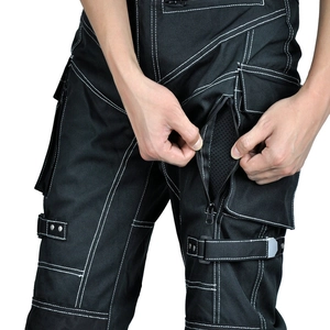 Detail of black tactical motorcycle pants with white stitching and mesh zipper pocket