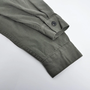 Détail du poignet de la veste moto vert olive avec texture sergé et bouton noir