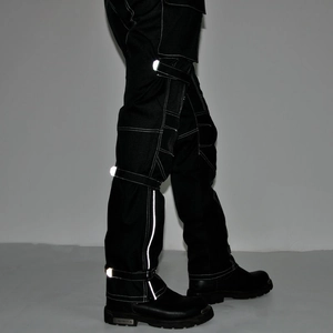 Detail of waterproof motorcycle pants featuring white contrast stitching and reflective strips