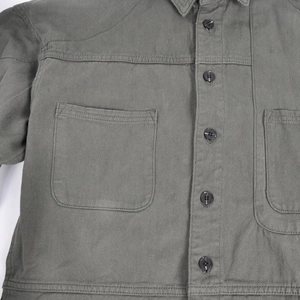Close-up of olive green motorcycle jacket with durable twill fabric and flap pockets