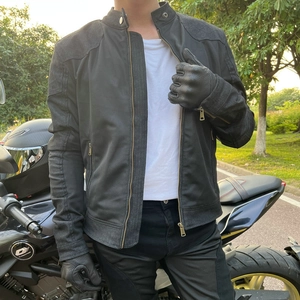 Close-up of black breathable motorcycle mesh jacket with metal zippers and leather gloves