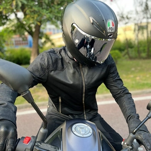 Detail of breathable mesh motorcycle jacket and carbon fiber texture helmet with visor