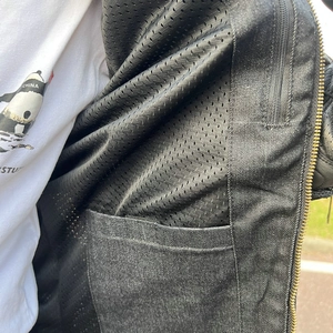 Detail of breathable mesh lining and interior pocket on motorcycle riding jacket