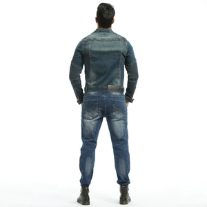 Detail of vintage blue-gray motorcycle denim jacket with elbow accordion panels and leather patch