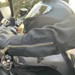 Close-up of motorcycle jacket cuff with vintage bronze zipper and mesh panel