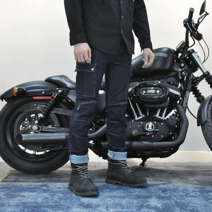 Detail of dark blue denim motorcycle pants with cargo pockets and stitched knee panels