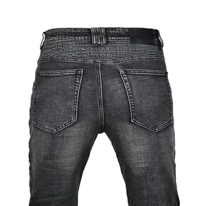 Detailed view of motorcycle jeans with ribbed accordion panels and leather back patch