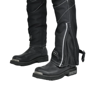 Détail de chaps de moto imperméables avec rivets en métal et bottes de moto robustes