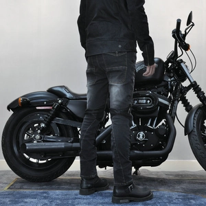 Detail of motorcycle denim pants featuring reinforced knee padding and heavy wash fabric