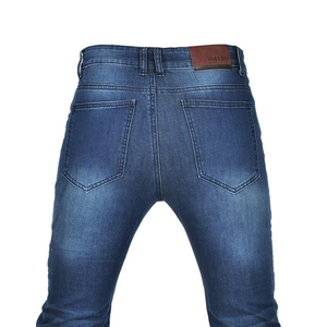Detail view of motorcycle jeans with vintage wash, reinforced seams and leather logo patch