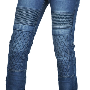 Close-up of accordion pleats and diamond quilted patches on biker denim pants