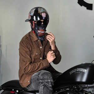 Close-up of retro biker look featuring oil wax jacket and vintage graphic helmet
