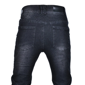 Gros plan sur les panneaux extensibles en accordéon et l'étiquette en cuir du jean biker