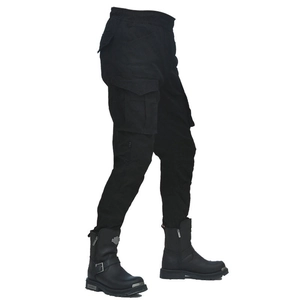 Dettaglio dei pantaloni cargo neri multitasche e degli stivali da motociclista in pelle