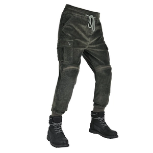 Detail view of olive green corduroy motorcycle pants and black high-top boots set