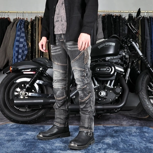 Detail of grey washed motorcycle jeans with accordion panels and reinforced stitching