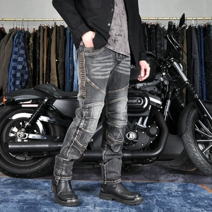 Detail of grey washed motorcycle jeans with accordion panels and reinforced stitching