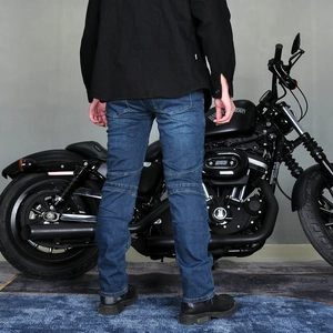 Détail du jean moto bleu extensible montrant les plis aux genoux et la coupe slim denim