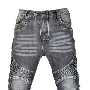 Close-up of dark gray washed biker jeans showing accordion pleated details on thighs