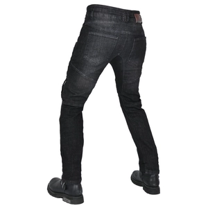 Detail view of motorcycle jeans with accordion stretch panels and leather brand patch