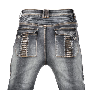 Detail view of motorcycle jeans with vintage wash effect and pleated waist design