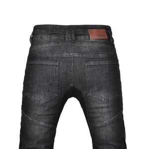 Detail view of motorcycle jeans with accordion stretch panels and brand leather patch