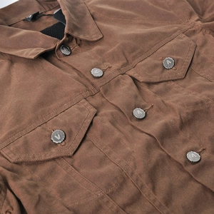 Close-up of brown waxed motorcycle jacket with metallic VOLERO buttons and canvas texture