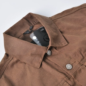 Detail of vintage brown waxed motorcycle jacket featuring silver embossed metal buttons