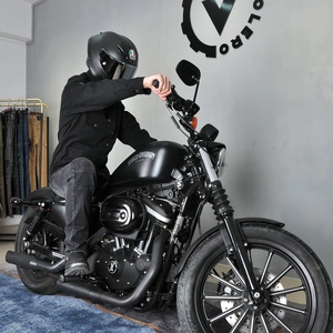 Detail of vintage motorcycle rider wearing a full protective gear and carbon fiber helmet
