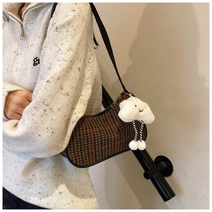 Detail der rot karierten Houndstooth-Achseltasche mit weißem Plüsch-Wolkenanhänger