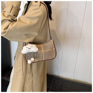 Detail der Vintage-Tasche mit Hahnentrittmuster und niedlichem Plüsch-Wolkenanhänger