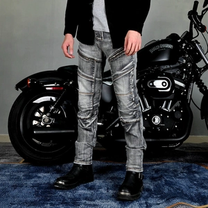 Detailed view of grey distressed motorcycle jeans with pleated knees and zipper accents