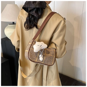 Detailansicht der braunen Karo-Achseltasche mit Lederriemen und Wolkenanhänger
