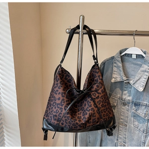 Detalle de bolso tote con estampado de leopardo, lazo negro y ribetes de cuero sintético