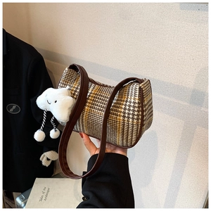 Nahaufnahme einer Retro-Hahnentritt-Schultertasche mit süßem Plüsch-Wolkenanhänger