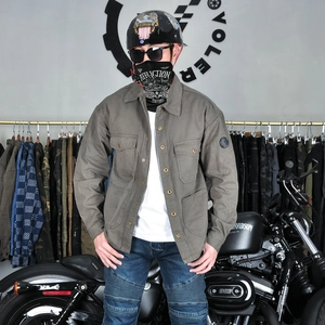 Detail of greyish-brown cotton motorcycle riding shirt with utility pockets and arm badge