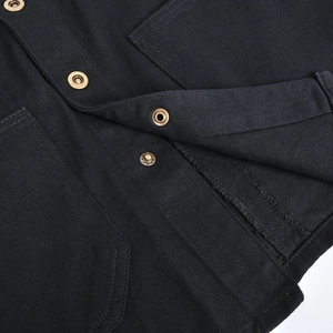 Macro detail of retro bronze metal buttons and durable twill fabric on black jacket