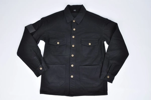 Close-up of black retro motorcycle jacket with gold buttons and four utility flap pockets