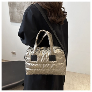 Detail van metallic zilveren gewatteerde tas met verstelbare zwarte schouderriem