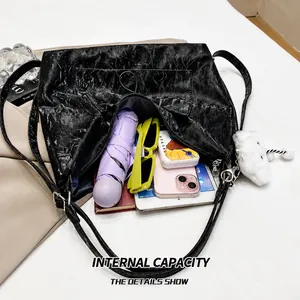 Intérieur spacieux du sac plissé noir montrant le rangement pour parapluie et tablette
