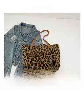 Close-up of leopard print faux fur tote bag with brown leather handles and soft texture
